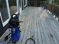 Using a pressure washer to clean a deck